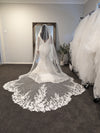"Bride lifting the blusher of the ALLIE veil to reveal the beaded trim and lace pattern."