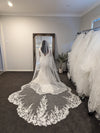 Full-length view of the ALLIE scalloped lace veil cascading over the bride’s gown