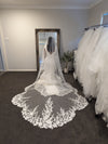 Bride wearing the ALLIE cathedral-length wedding veil with scalloped lace edge and beaded trim from comb to lace