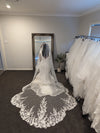 Bride wearing the ALLIE cathedral-length wedding veil with scalloped lace edge and beaded trim from comb to lace
