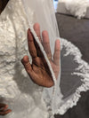 "Top view of the ALLIE veil laid flat, showcasing the scalloped lace edge and flowing tulle."