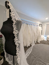 "Bride walking down the aisle wearing the ELIKA cathedral-length veil, capturing its graceful flow."