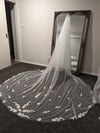 Bride wearing the SAMANTHA cathedral-length wedding veil, featuring 3D floral petals embellished with pearls and lace appliqués.