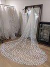 Bride wearing two-tier cathedral wedding veil with delicate lace floral appliqués