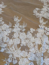 "Close-up of a delicate lace veil with sequins. The veil features intricate floral patterns and a touch of sparkle from the sequins."